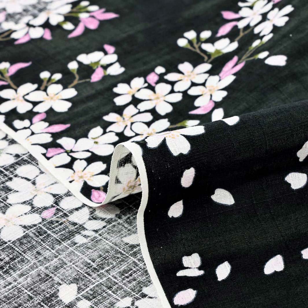 photo packshot zoomée d'un détail du tissu japonais aux motifs de fleurs de cerisier dessinées dans les tons noirs, roses et vert T552