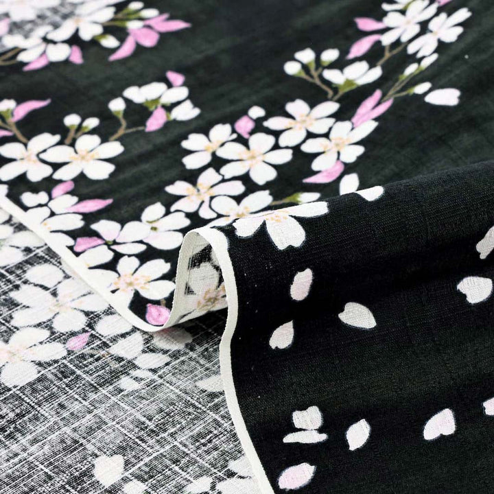 photo packshot zoomée d'un détail du tissu japonais aux motifs de fleurs de cerisier dessinées dans les tons noirs, roses et vert T552