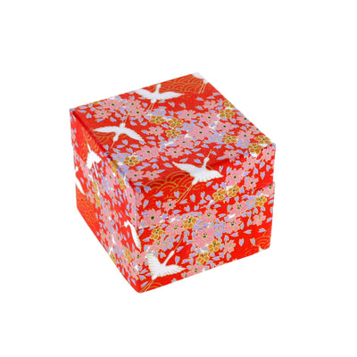 boîte fermée tapissée d'un papier japonais yuzen adeline klam aux motifs d'envolée de grues et de fleurs sur fond rouge (M322) contenant 200 papiers origami de 6 cm x 6 cm aux motifs variés traditionnels