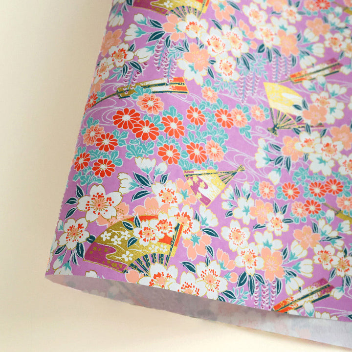 photo packshot d'une courbe de papier japonais yuzen chiyogami aux motifs de fleurs de cerisier, de chrysanthèmes, de glycines et d'éventails dans les tons mauve, pâche, rouges, vert d'eau et blancs adeline klam (M1015)