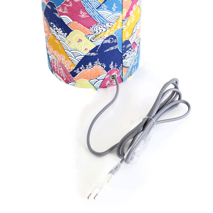 détail d'un câble électrique gris d'une lampe japonaise à poser aux motifs de montagnes et de rivières dans les tons bleus, orange, jaunes et mauve (M966) adeline klam