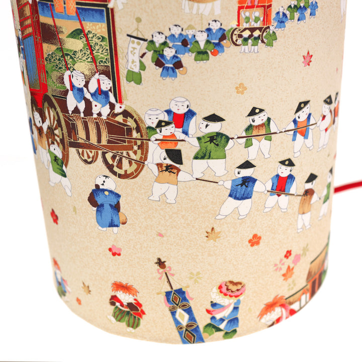 zoom sur lampe japonaise à poser aux motifs de scénettes d'un festival japonais dans les tons beiges, rouges, bleus, verts, orange et marrons adeline klam
