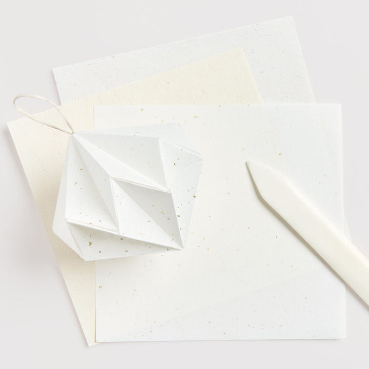 photo d'ambiance du set de 30 papiers origami unis mouchetés blancs, beiges et ivoires de 15cm par 15cm rico design