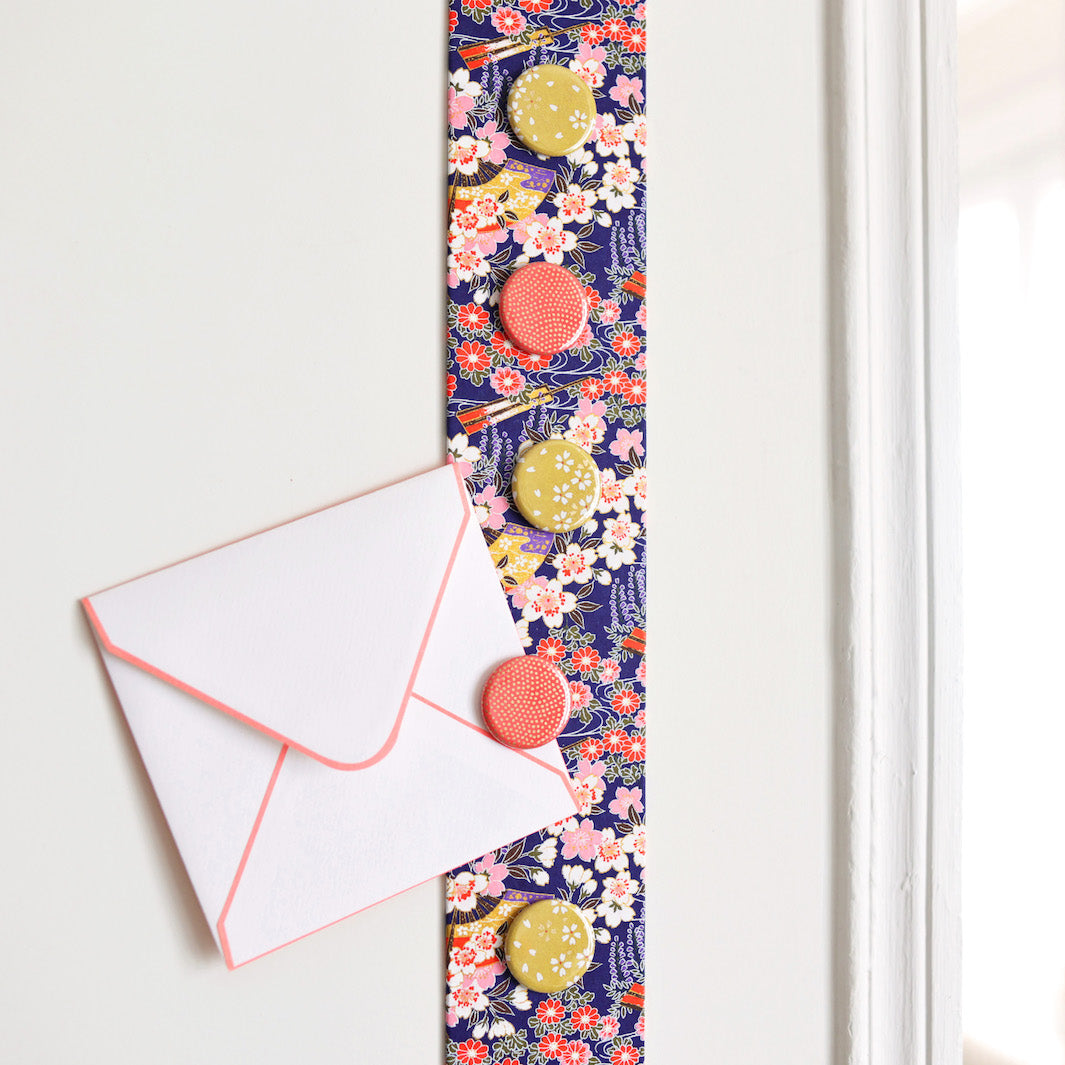 photo d'ambiance avec une vue zoomée du pêle-mêle tapissé du papier japonais aux motifs de fleurs de cerisier, de chrysanthèmes, de glycines et d'éventails dans les tons violets, roses, blancs et rouges M908 adeline klam