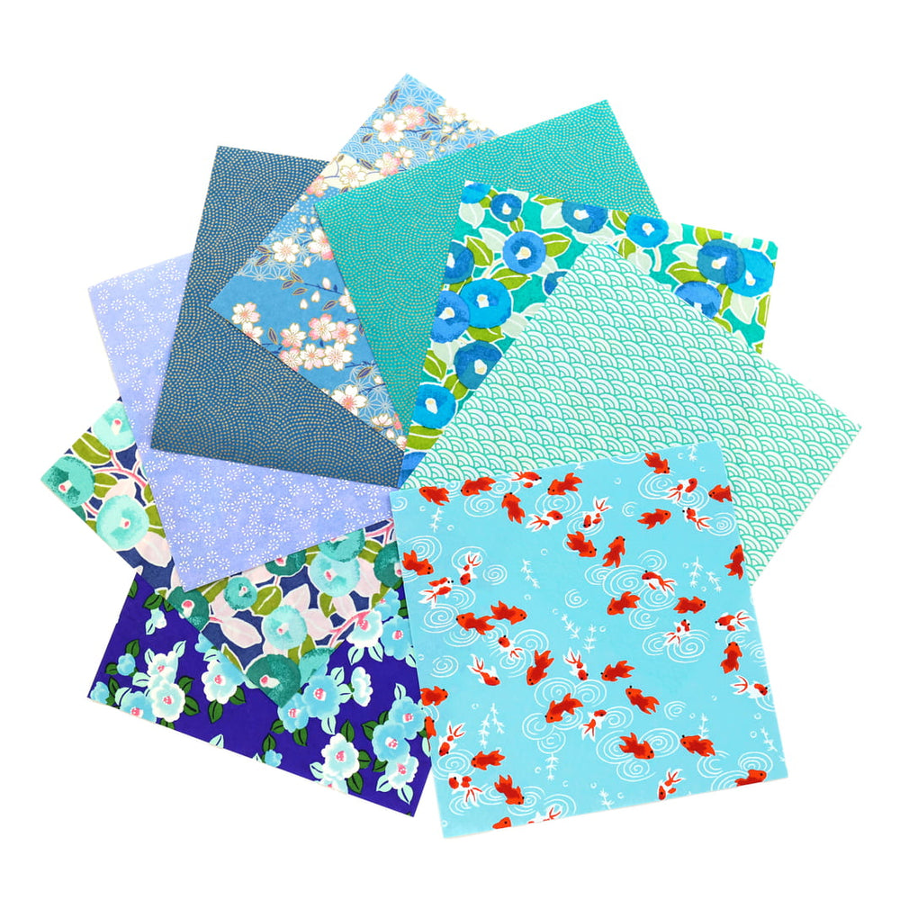photo packshot de l'assortiment de papiers japonais du set de 20 carrés de papiers japonais adeline klam de 15cm par 15cm dans les tons bleu canard, vert d'eau, bleu nuit, turquoise et violets « paon »
