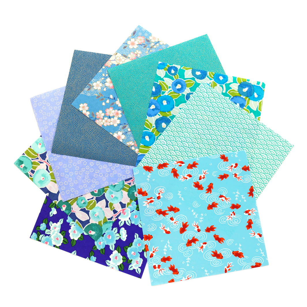 photo packshot de l'assortiment de papiers japonais du set de 20 carrés de papiers japonais adeline klam de 15cm par 15cm dans les tons bleu canard, vert d'eau, bleu nuit, turquoise et violets « paon »