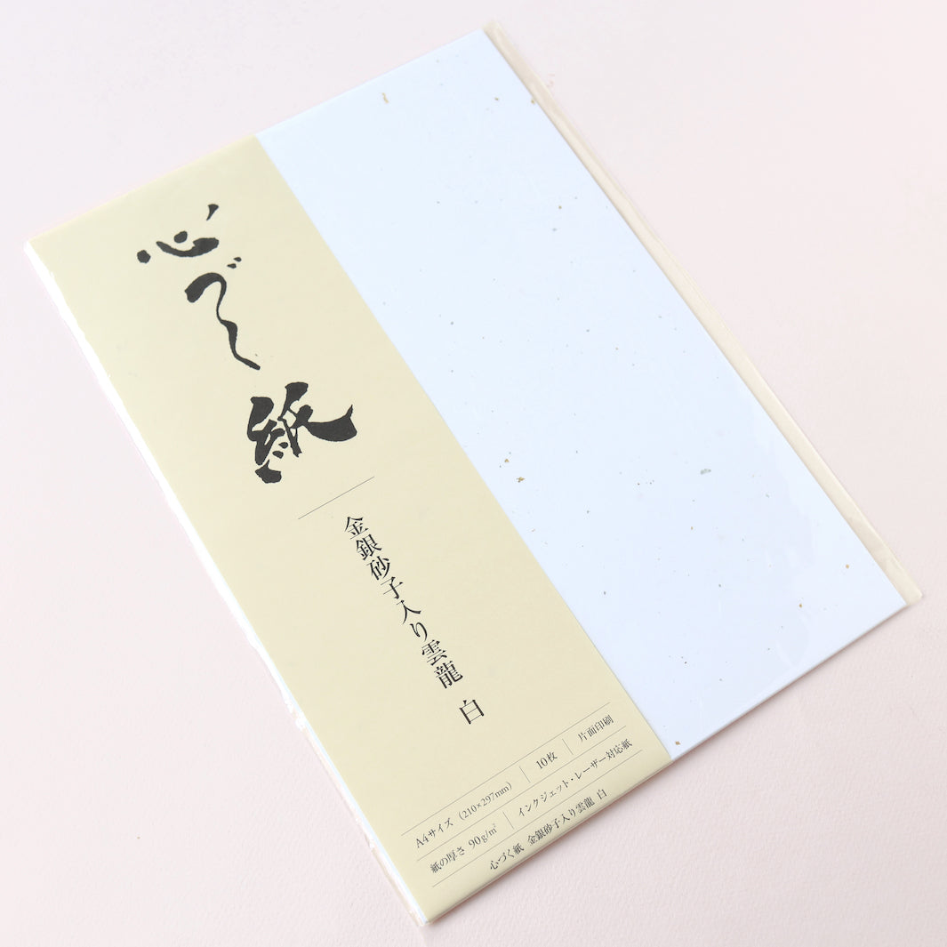 photo packshot de biais du bloc de 10 papiers blancs « shinzukushi » aux inscrustations unryu dorées et argentées de 210 par 297mm