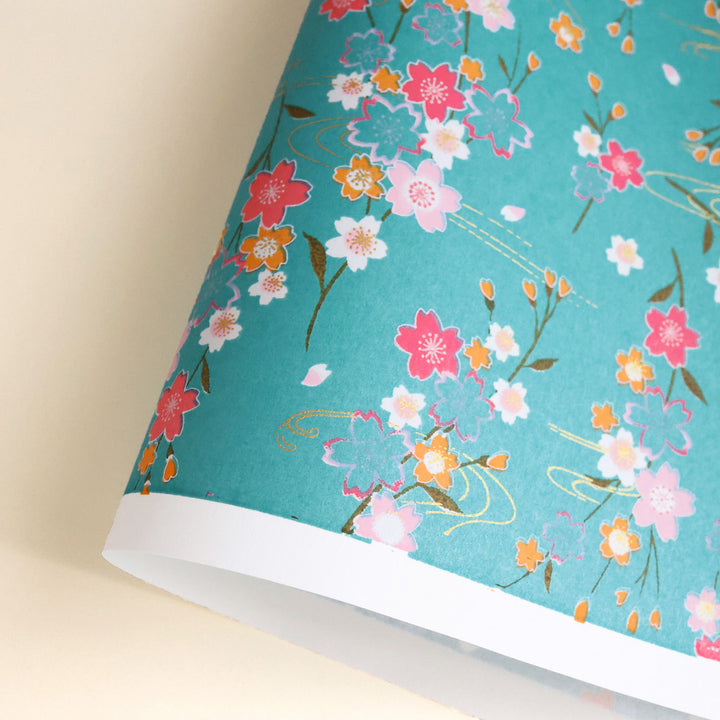 photo packshot d'une courbe de papier japonais yuzen chiyogami aux motifs de branches de cerisier et d'ondulations dans les tons bleu turquoise, rose fuchsia, jaune orange et dorés adeline klam (M380)