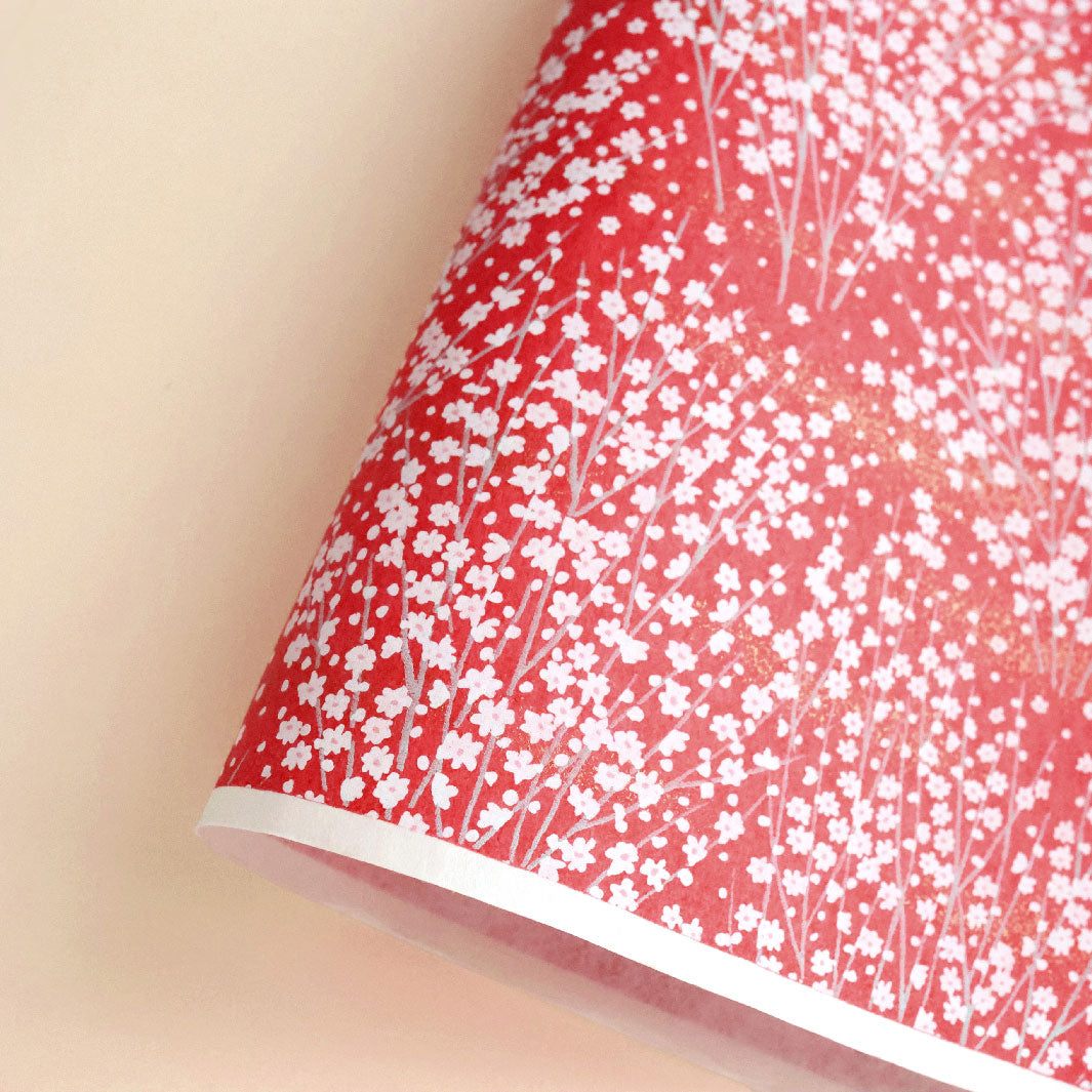 photo packshot d'une courbe de papier japonais yuzen chiyogami aux motifs de champs de fleurs dans les tons rouges (M813)