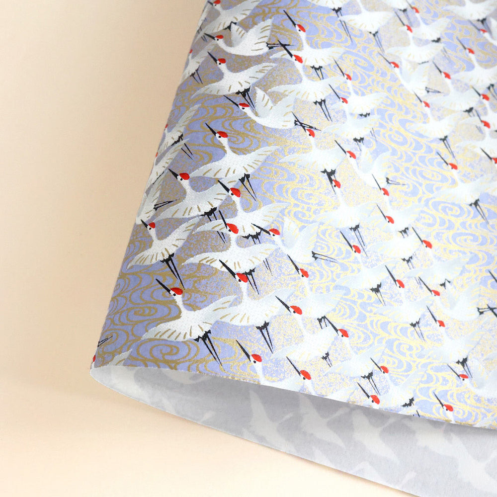 photo packshot d'une courbe de papier japonais yuzen chiyogami aux motifs d'envolée de grues dans les tons bleu lavande adeline klam (M388)
