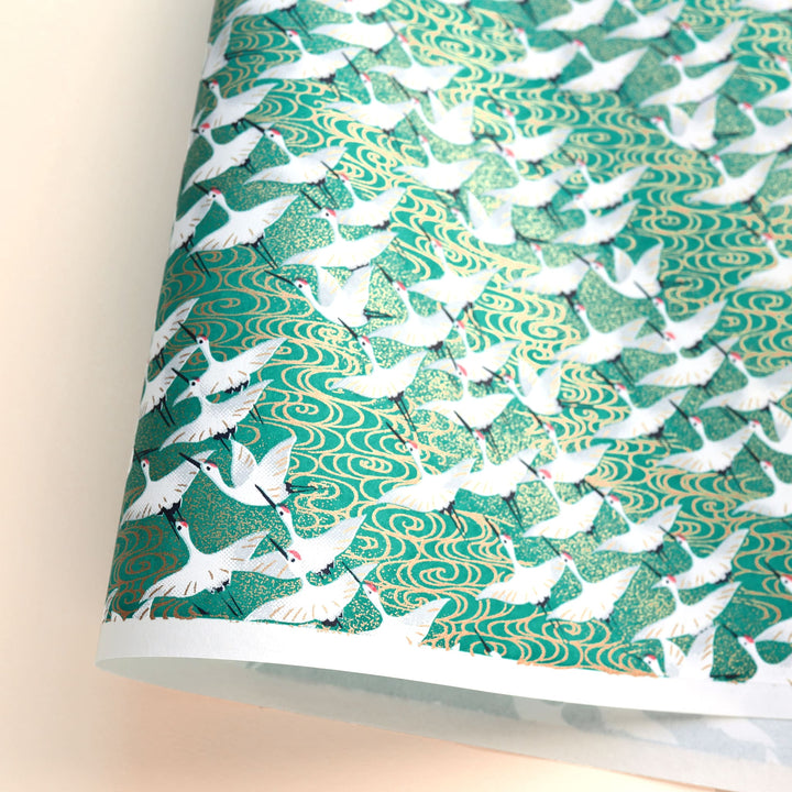 photo packshot d'une courbe de papier japonais yuzen chiyogami aux motifs d'envolée de grues blanches sur fond vert adeline klam (M931)