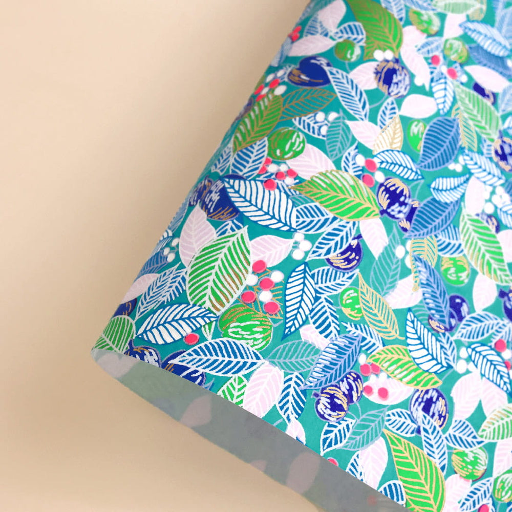 photo packshot d'une courbe de papier japonais yuzen chiyogami aux motifs de feuilles, de baies et de fruits dans les tons turquoise, bleus, verts et rose (M854)