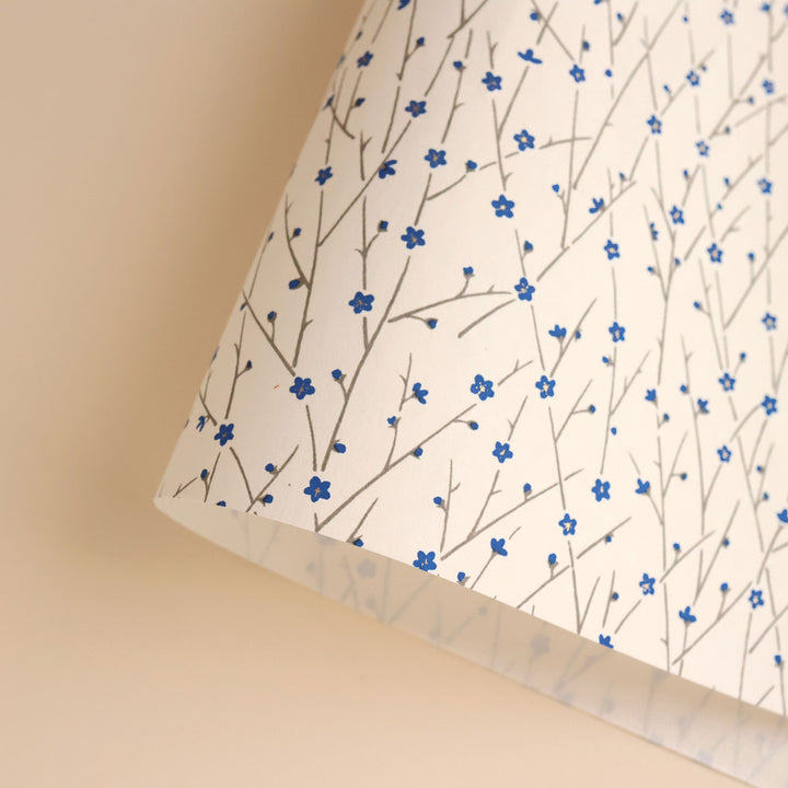 photo packshot d'une courbe de papier japonais yuzen chiyogami aux motifs de fines branches en fleurs dans les tons blanc crème, bleus et gris (M981)