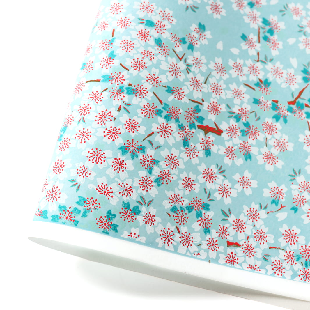 photo packshot d'une courbe de papier japonais yuzen chiyogami au motif de fleurs de cerisier dans les tons bleu ciel, bleu turquoise, rouges et blancs adeline klam (M580)