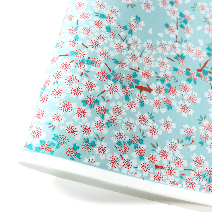 photo packshot d'une courbe de papier japonais yuzen chiyogami au motif de fleurs de cerisier dans les tons bleu ciel, bleu turquoise, rouges et blancs adeline klam (M580)
