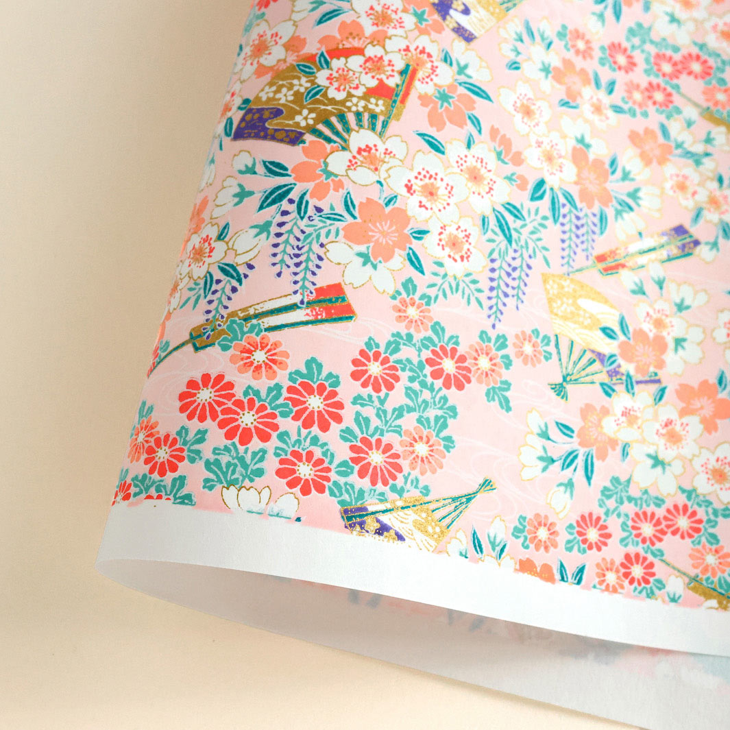 photo packshot d'une courbe de papier japonais yuzen chiyogami aux motifs de fleurs de cerisier, de chrysanthèmes, de glycines et d'éventails dans les tons rose clair, corail, rouges, roses, verts et blancs adeline klam M1014