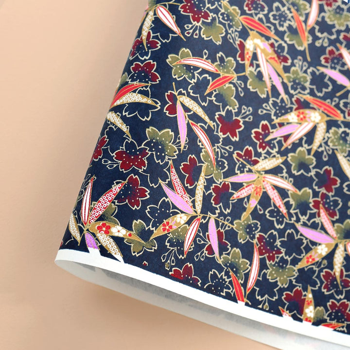 photo packshot d'une courbe de papier japonais yuzen chiyogami aux motifs de  fleurs de cerisier et de feuilles de bambou dans les tons bleu marine, jaune moutarde, rouges, mauve et dorés adeline klam (M1029)