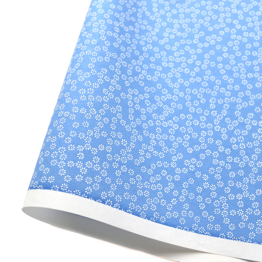 photo packshot d'une courbe de papier japonais yuzen chiyogami aux motifs de semi de fleurs blanches sur fondbleu pervenche adeline klam (M547)