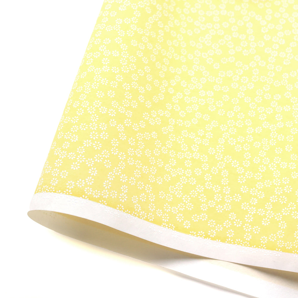 photo packshot d'une courbe de papier japonais yuzen chiyogami aux motifs de semi de fleurs blanches sur fond jaune pastel adeline klam (M528)