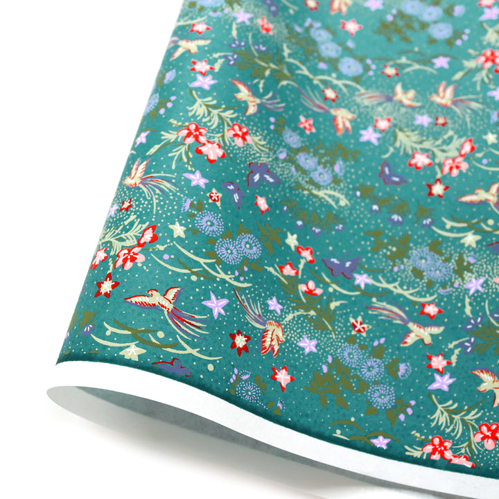 photo packshot d'une courbe de papier japonais yuzen chiyogami aux motifs de fleurs, d'oiseaux et de papillons dans les bleu canard, violets, vert clair et foncé, jaune pâle adeline klam (M1066)