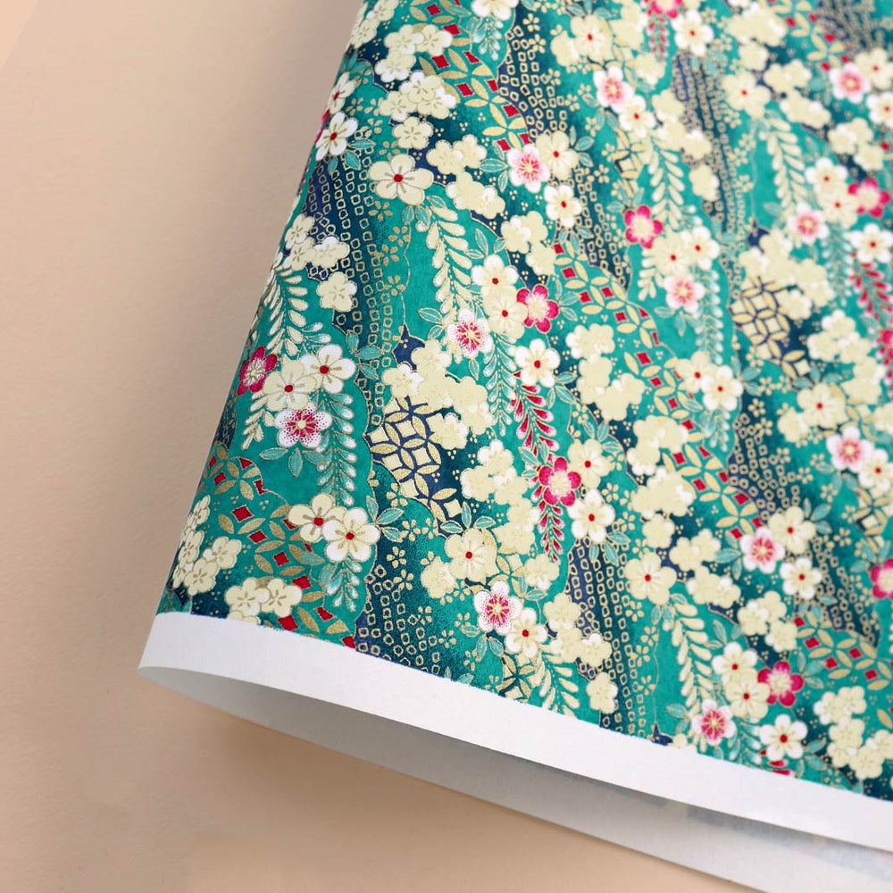 photo packshot d'une courbe de papier japonais yuzen chiyogami aux motifs de fleurs de prunier et de nuages à motifs dans les tons bleu turquoise, jaune pâle, rose fuchsia et dorés adeline klam (M1031)