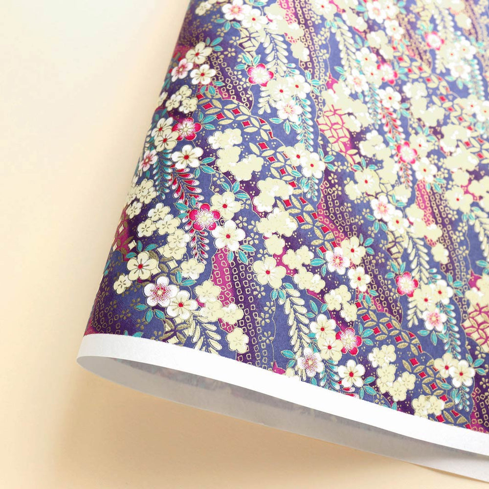 photo packshot d'une courbe de papier japonais yuzen chiyogami aux motifs de fleurs de prunier et de nuages à motifs dans les tons jaune pâle, magenta, violets, mauve et bleus et dorés adeline klam (M1020)