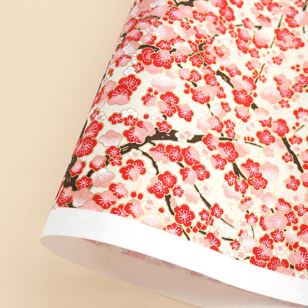 photo packshot d'une courbe de papier japonais yuzen chiyogami aux motifs de fleurs de prunier dans les tons rouges, roses et crème adeline klam (M593)