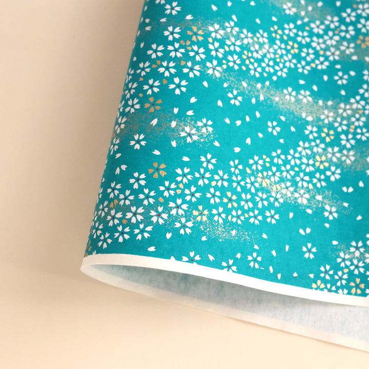 photo packshot d'une courbe du papier japonais yuzen chiyogami aux motifs de fleurs au vent blanche sur fond bleu canard clair adeline klam (M668)
