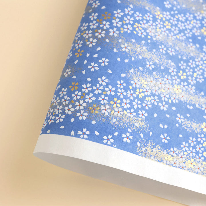 photo packshot d'une courbe de papier japonais yuzen chiyogami aux motifs de fleurs au vent sur fond bleu pervenche adeline klam (M983)