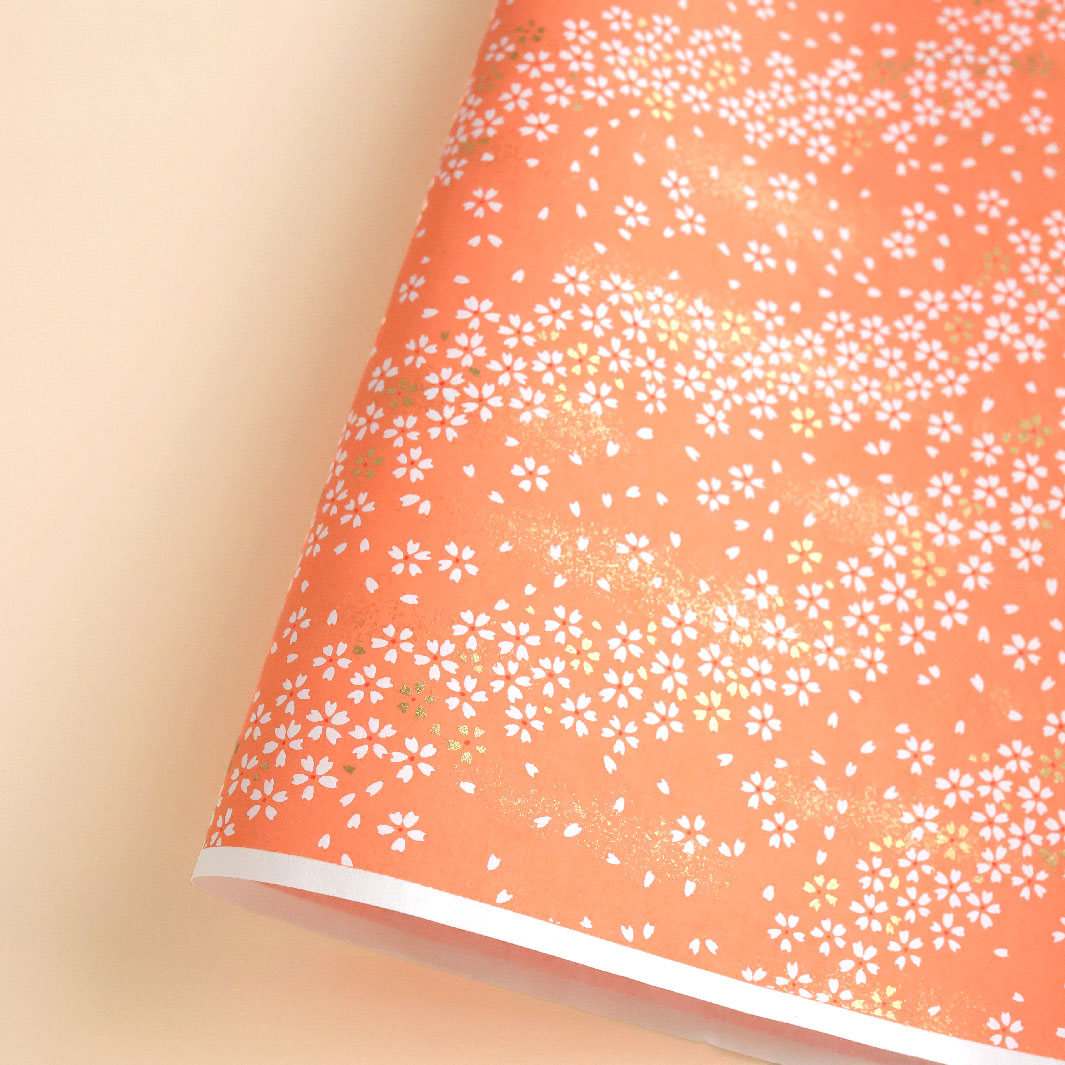 photo packshot d'une courbe de papier japonais yuzen chiyogami aux motifs de fleurs au vent dans les tons orange saumon (M865)