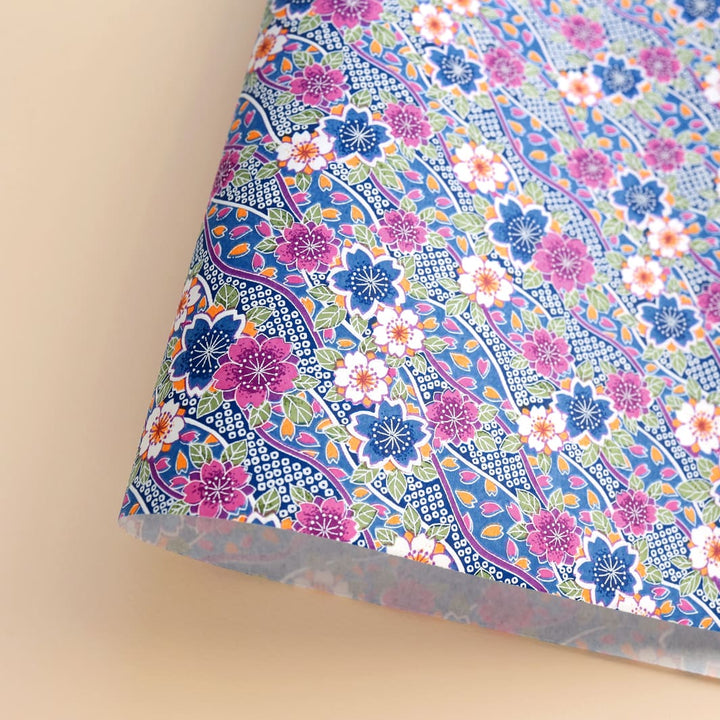 photo packshot d'une courbe de papier japonais yuzen chiyogami aux motifs d'ondulations fleuries dans les tons bleus, violets, corail, verts et blancs adeline klam (M508)