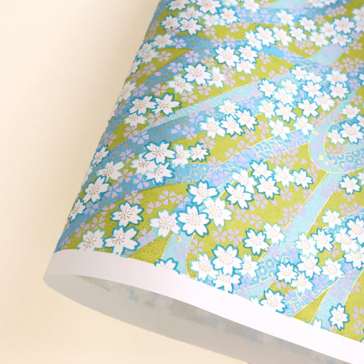 photo packshot d'une courbe de papier japonais yuzen chiyogami aux motifs d'ondulations fleuries dans les tons jaune vert, bleus, mauve, vert d'eau, lilas et dorés adeline klam (M1001)