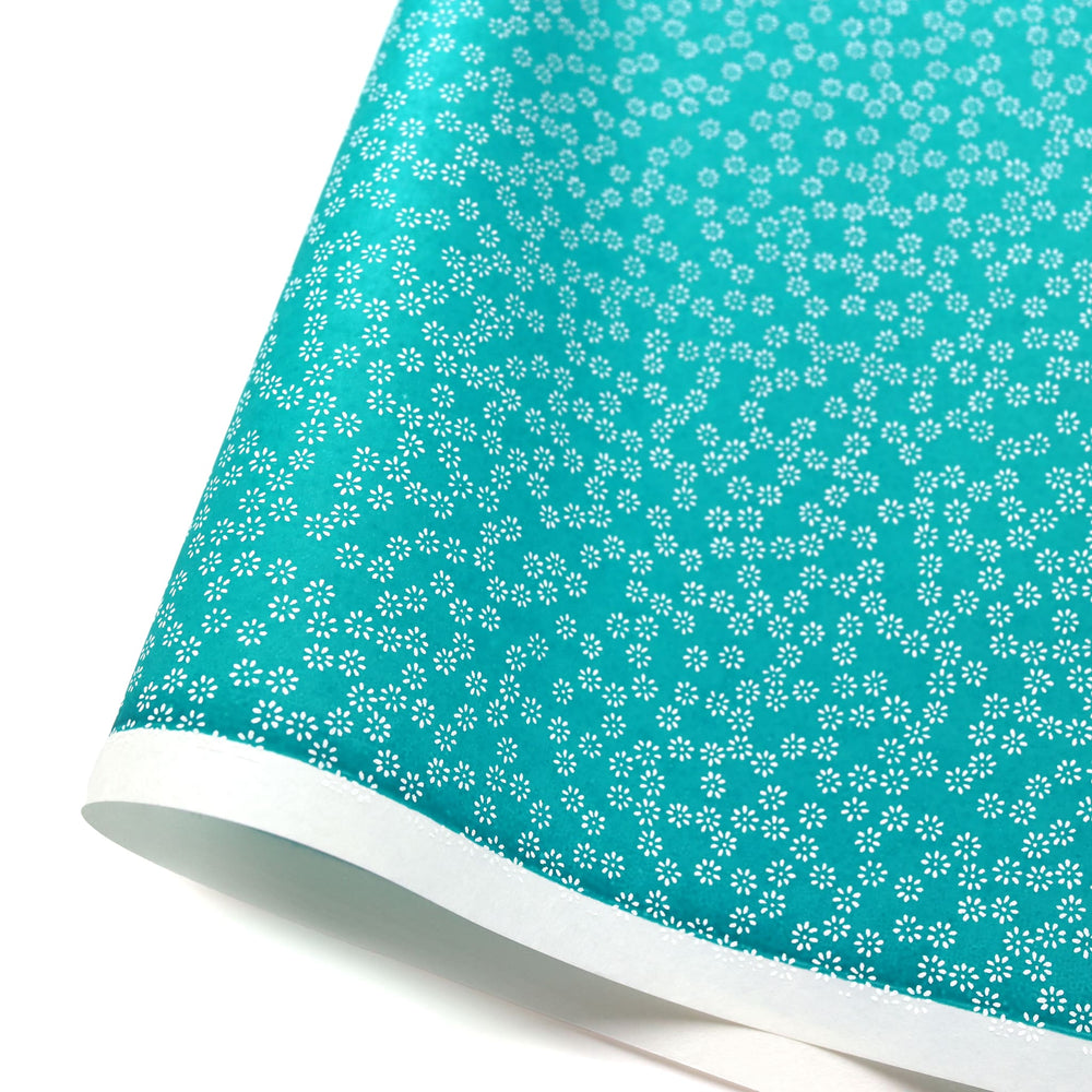 photo packshot d'une courbe de papier japonais yuzen chiyogami aux motifs de semi de fleurs blanches sur fond bleu turquoise adeline klam (M539)