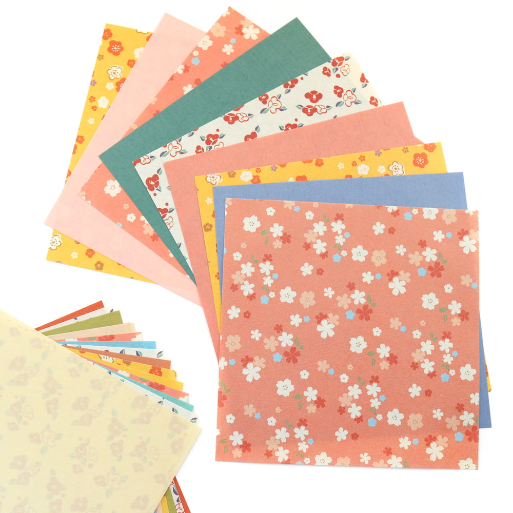 photo packshot d'un détail de l'assortiment de papiers du set de 24 papiers origami en 15cm par 15cm aux motifs fleuris et unis dans un mélange hana furukawashiko