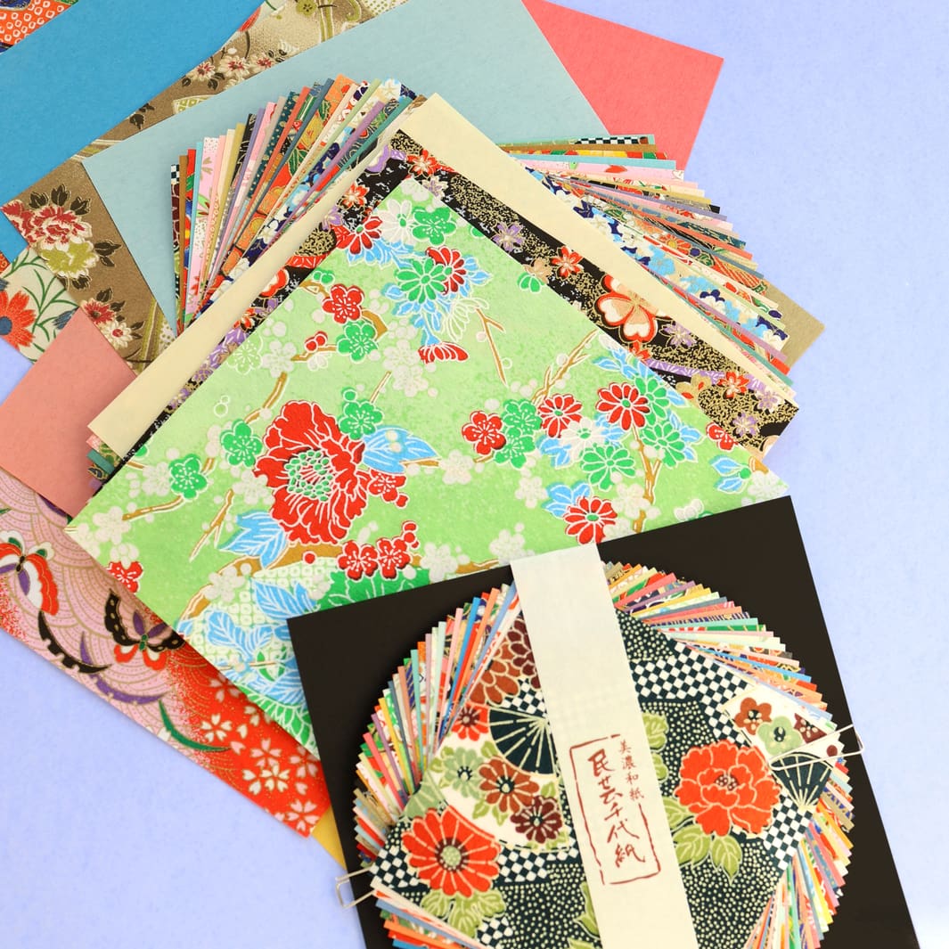 photo packshot d'un détail de l'assortiment de papiers du set de 40 papiers origami en 15cm par 15cm aux motifs traditionnels et unis dans un mélange folklorique furukawashiko