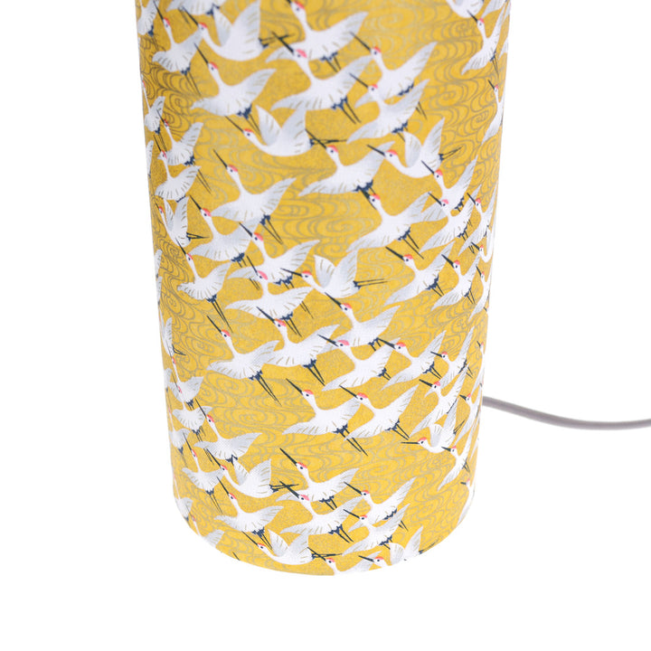 photo packshot d'un détail du câble électrique gris de la lampe japonaise à poser aux motifs d'envolée de grues blanches sur fond jaune moutarde (M930) adeline klam