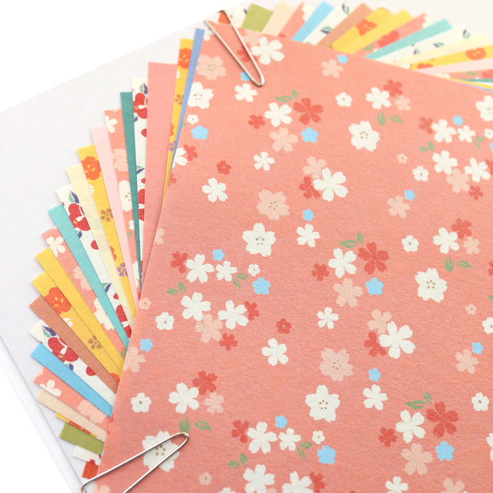 photo packshot d'un détail du packaging du set de 24 papiers origami en 15cm par 15cm aux motifs fleuris et unis dans un mélange hana furukawashiko