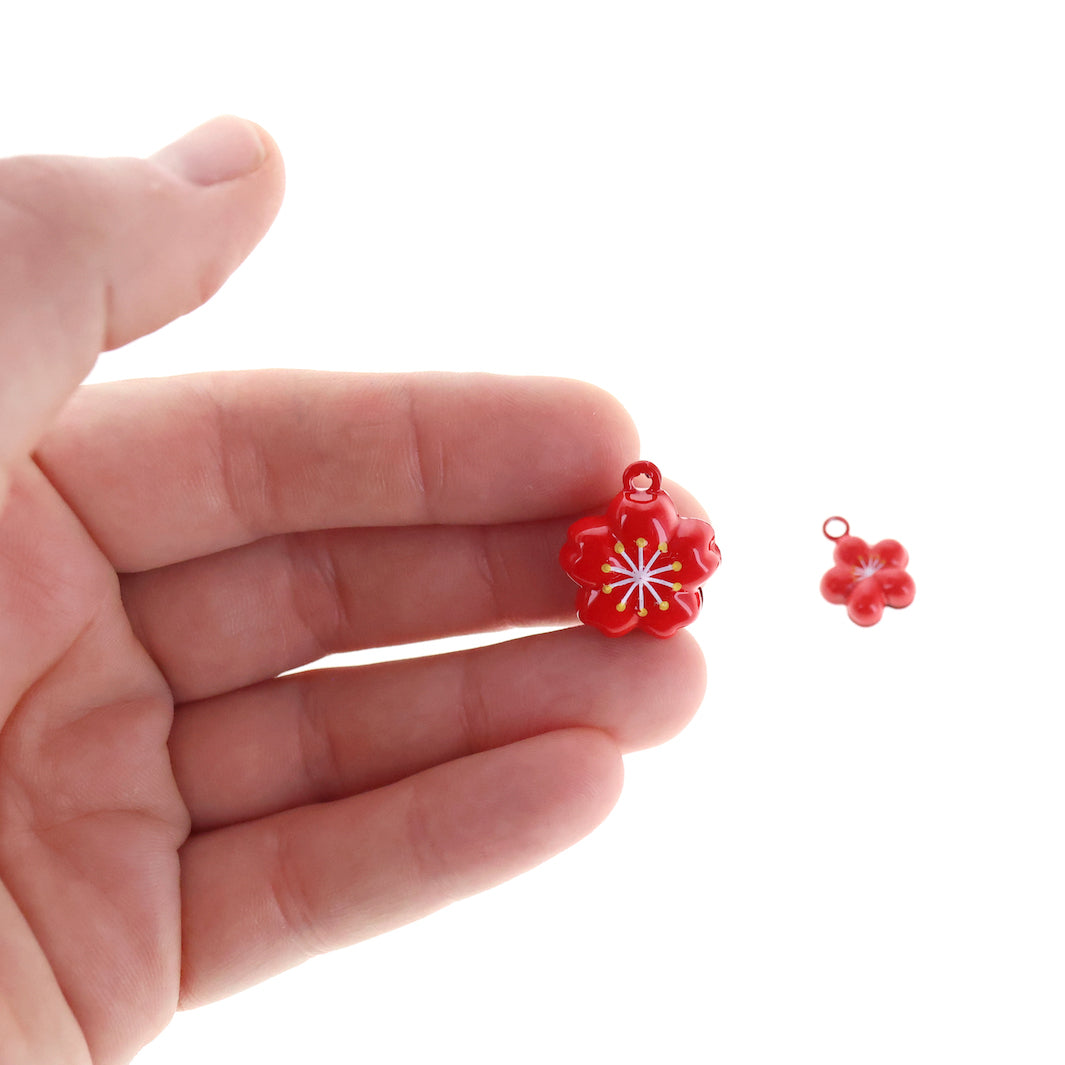 photo packshot d'un détail de taille du petit et du grand modèle de grelot en forme de fleur de cerisier rouge