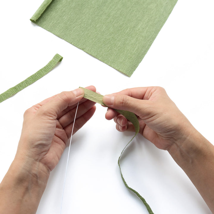 photo packshot de démonstration de l'étape 2 de d'habillage de tiges avec du papier crépon (562) pour le kit bouquet de fleurs en crépon « agrume » adeline klam