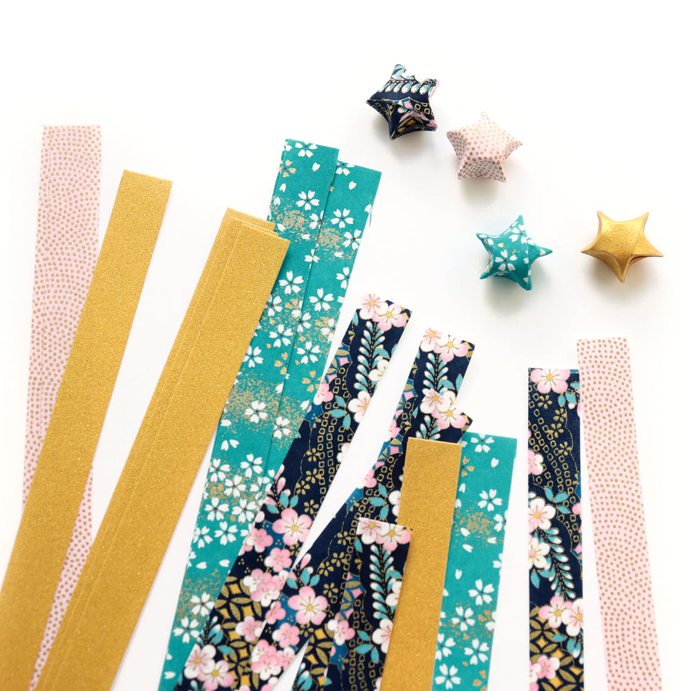photo packshot des étoiles montées et des bandelettes de papiers japonais du kit étoiles en origami dans les tons bleu canard et marine, rose pâle et dorés « nocturne » adeline klam