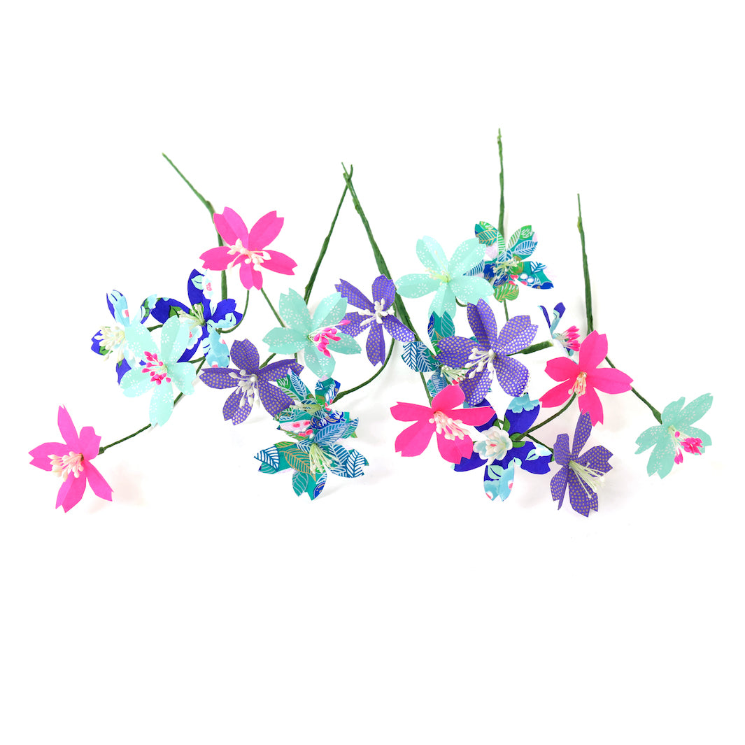 photo packshot des fleurs montées et posées à plat du kit bouquet de fleurs de cerisier dans les tons bleu nuit, vert d'eau et rose fluo « fantastique » adeline klam