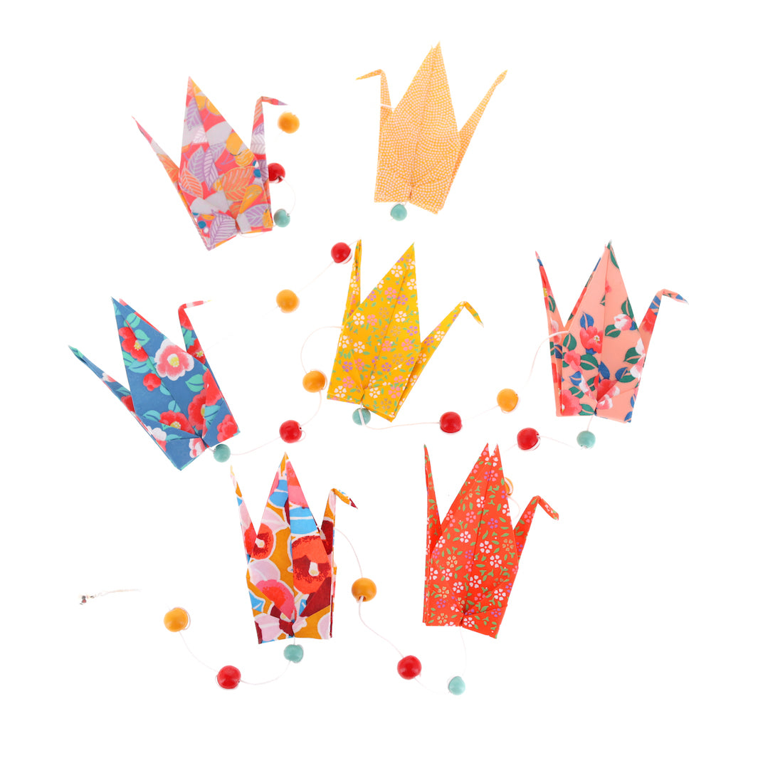 photo packshot de la guirlande montée du kit créatif guirlande de grues en origami « singapour » (A7) dans les tons jaune moutarde, rouge orange et bleus adeline klam