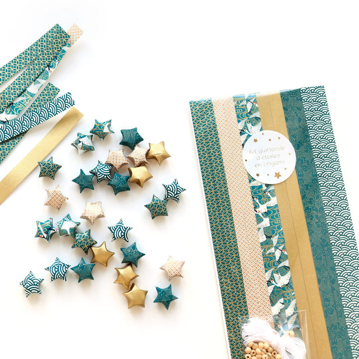 photo packshot du packaging, des étoiles et des bandelette de papier japonais du kit guirlande d'étoiles en origami bleu canard, blanc et doré « orient » adeline klam