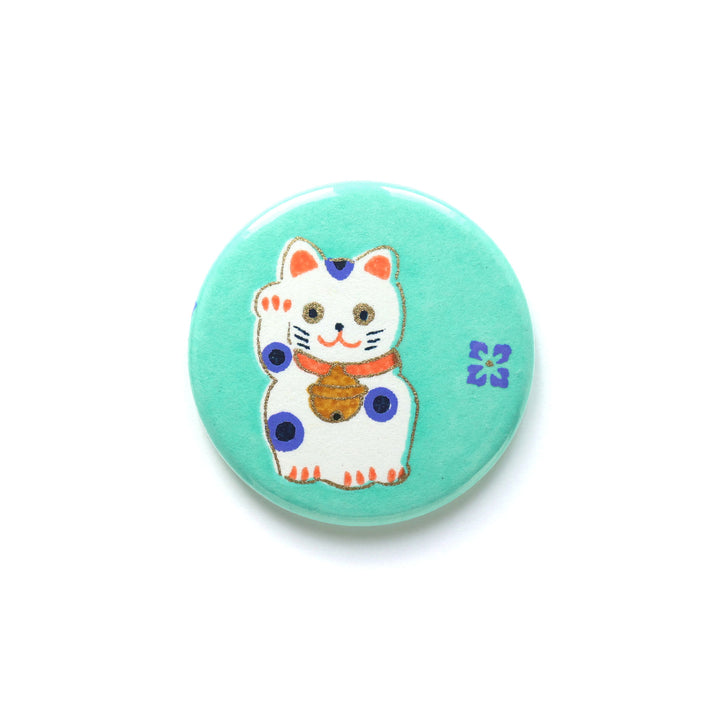 photo packshot du recto de l'aimant en papier japonais de 45mm de diamètre aux motifs de maneki-neko blancs aux détails orange et bleu violet sur fond vert menthe (M838) adeline klam