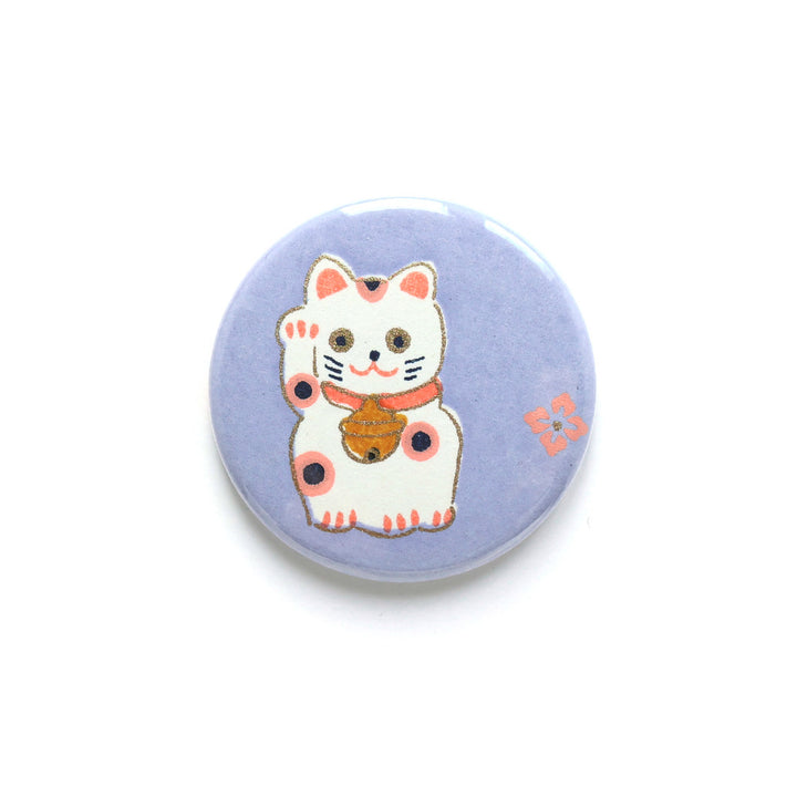 photo packshot du recto de l'aimant en papier japonais de 45mm de diamètre aux motifs de maneki-neko blancs aux détails roses, corail et jaune moutarde sur fond violet lilas (M839) adeline klam