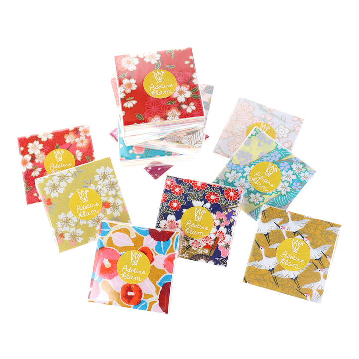 photo packshot de sets de 100 carrés de papiers japonais adeline klam de 6cm par 6cm dans les tons jaunes, orange, rouges, roses et bleu turquoise « multifruits »