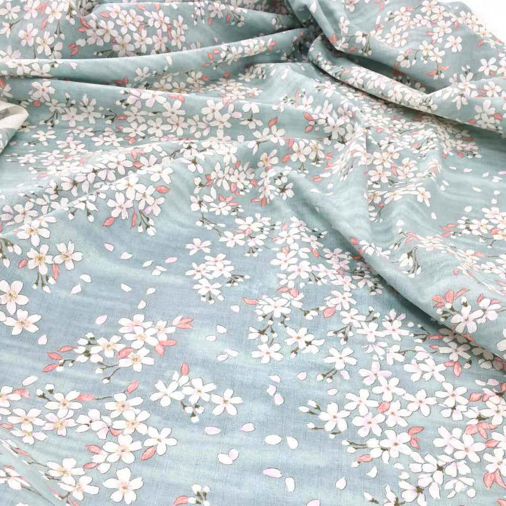 photo packshot du tombé du tissu japonais aux motifs de fleurs de cerisier dessinées dans les tons bleu gris, rose corail et blanc T551