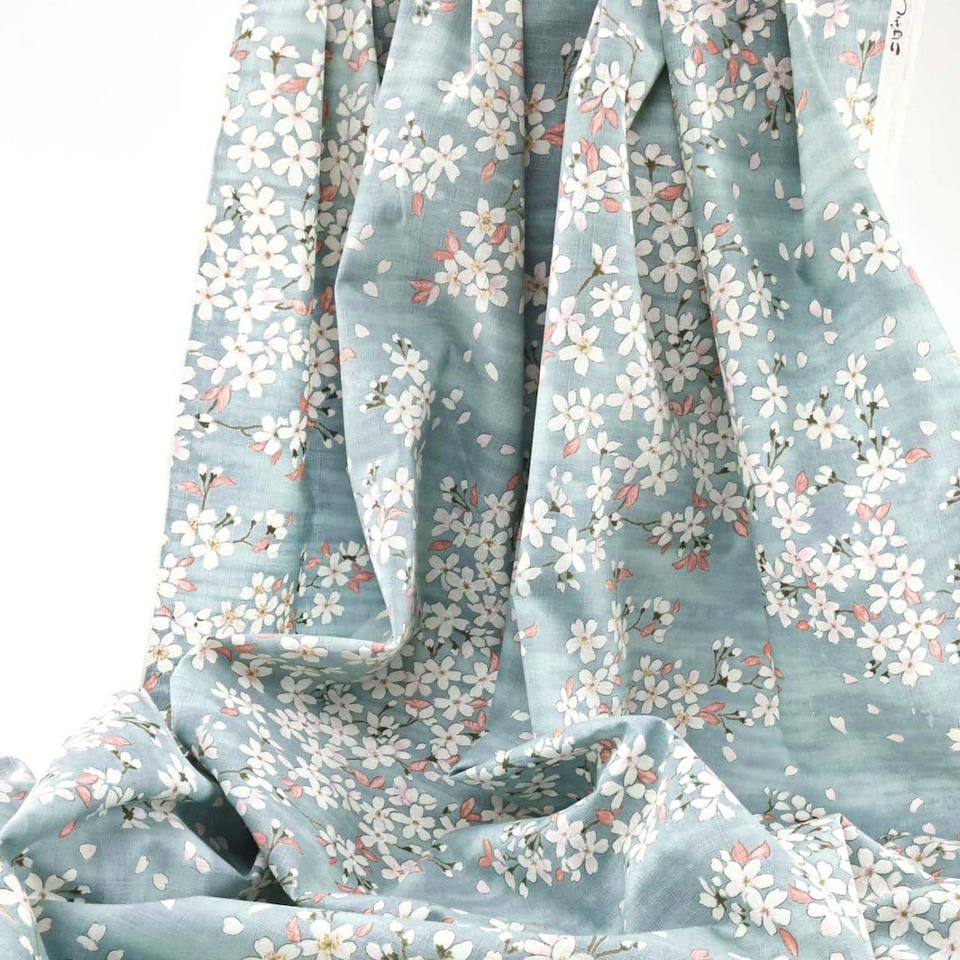 photo packshot du tissu japonais aux motifs de fleurs de cerisier dessinées dans les tons bleu gris, rose corail et blanc T551