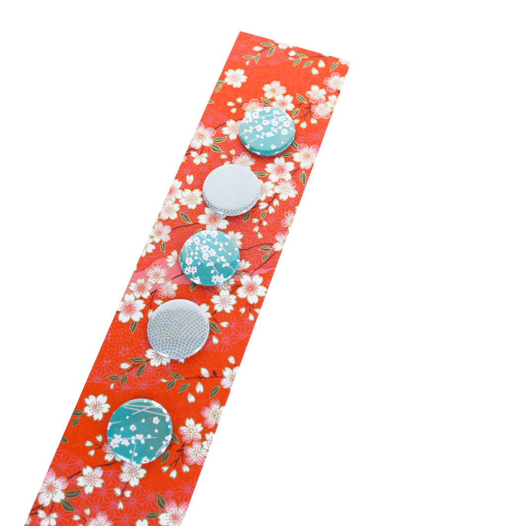 photo packshot avec une vue de biais du pêle-mêle tapissé du papier japonais aux motifs de fleurs de cerisier et de dessins variés blanc crème, rose clair et rouge orangé M385 adeline klam