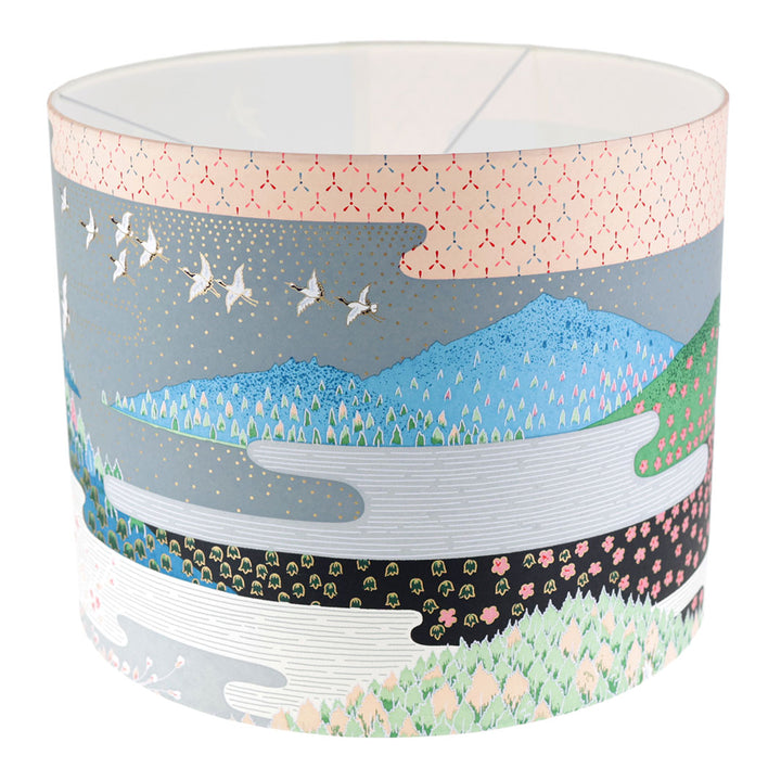 photo packshot avec une vue de face d'un abat-jour japonais au motif de paysage japonais (ciel et montagne) dans les tons bleus, verts, gris, noirs, orange et roses
